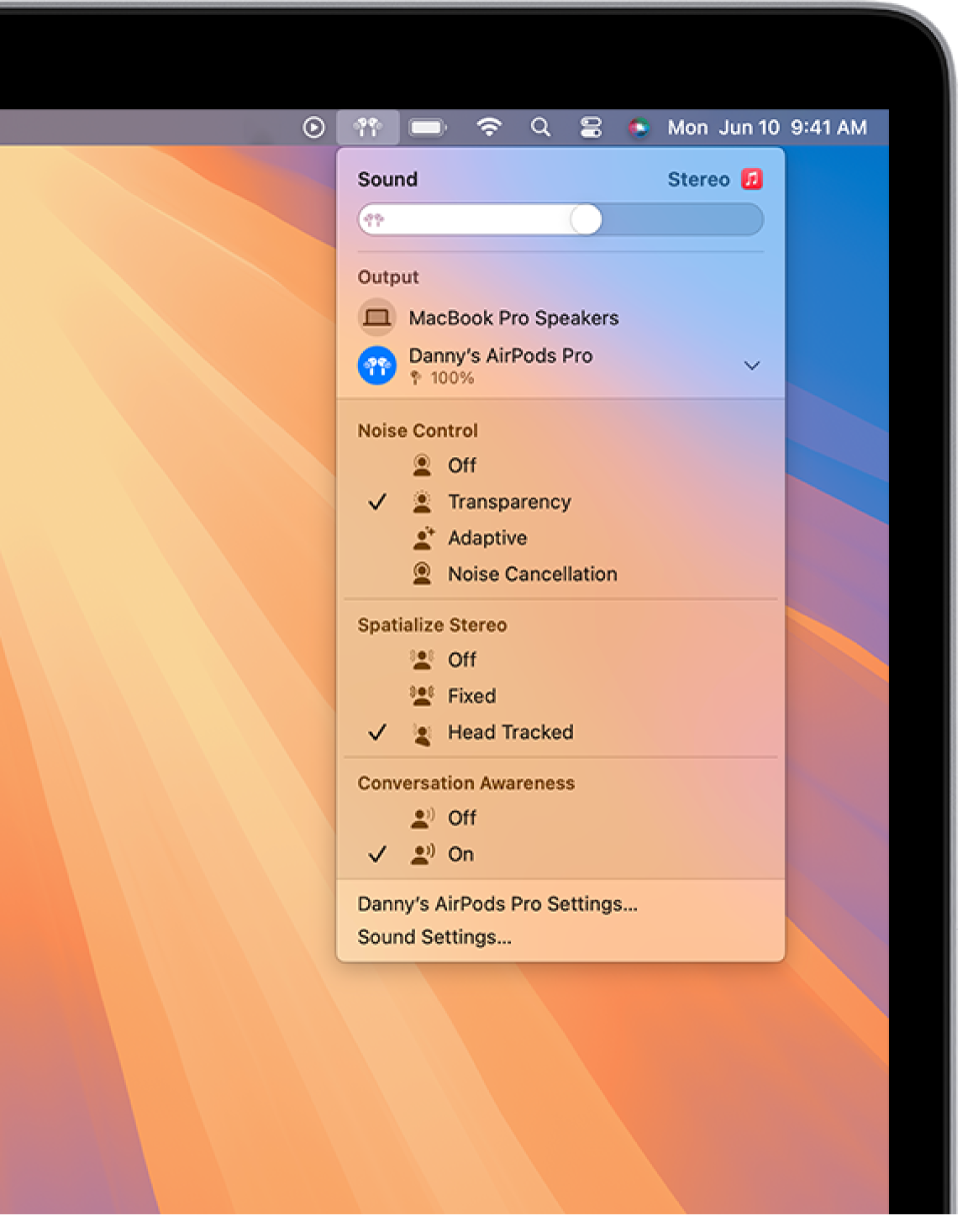 A MacBook Pro screen with a song playing in the Music app. In the menu bar, the AirPods icon is selected and a menu shows AirPods with Transparency and head tracked Spatial Audio on.